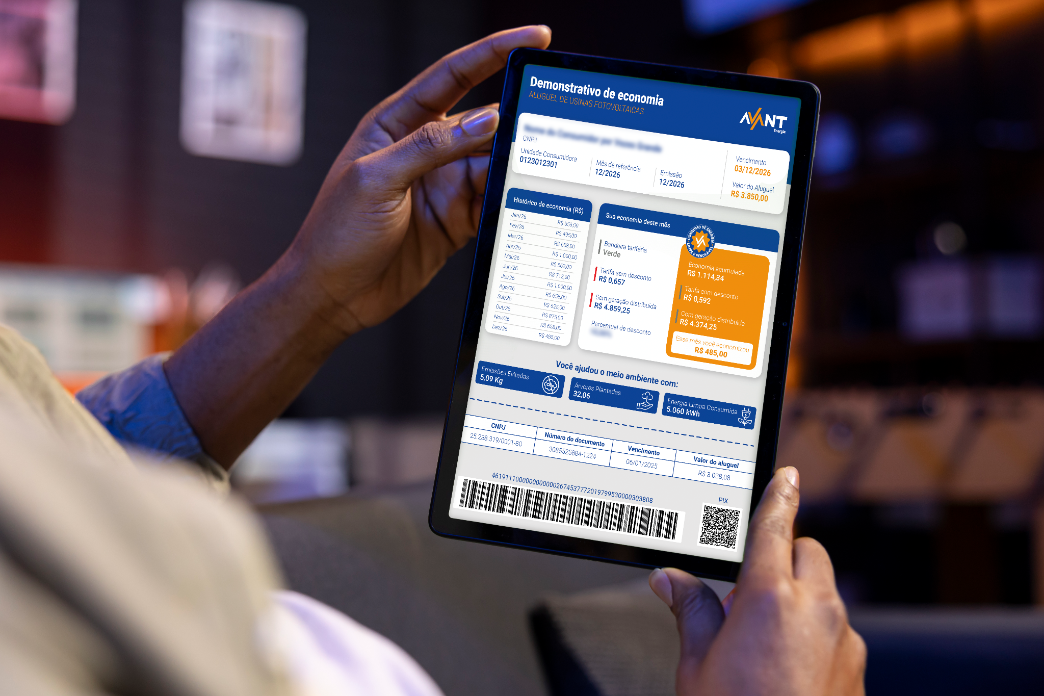 Pessoa segurando um tablet com demonstrativo de economia da AVANT Energia